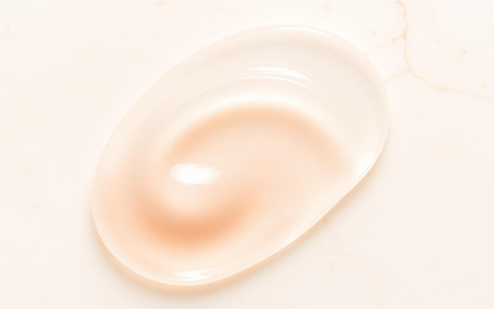 Translucent ELUNÉ skincare texture on pale stone